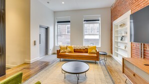 A modern living room with a sofa, coffee table, and a brick accent wall.