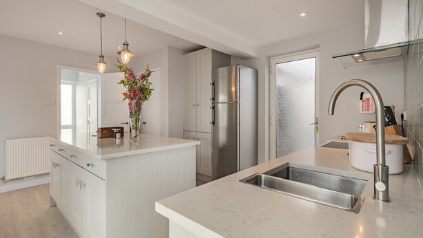 A modern kitchen with a central island, stainless steel appliances, and a glass backsplash. - A stunning location for exploring the stunning North Norfolk Coast. (Brancaster Staithe, near King&rsquo;s Lynn)