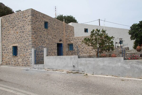 Un bâtiment en pierre avec un petit jardin à l’avant.