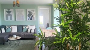 A living room with a sofa, a coffee table, and a large green plant. - Lisbon, T2 renewed duplex with river view, Beato (Lisboa ciudad)