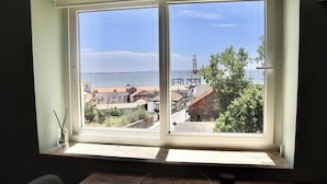 A room with a large window overlooking a cityscape, a wooden table, and a chair. - Lisbon, T2 renewed duplex with river view, Beato (Lisboa ciudad)