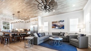 A modern kitchen with a central island, bar stools, and a dining area. - August Dates Still Available! 5BR Luxury Home, Pool & Golf Cart • 3 Min to Beach (Miramar Beach)