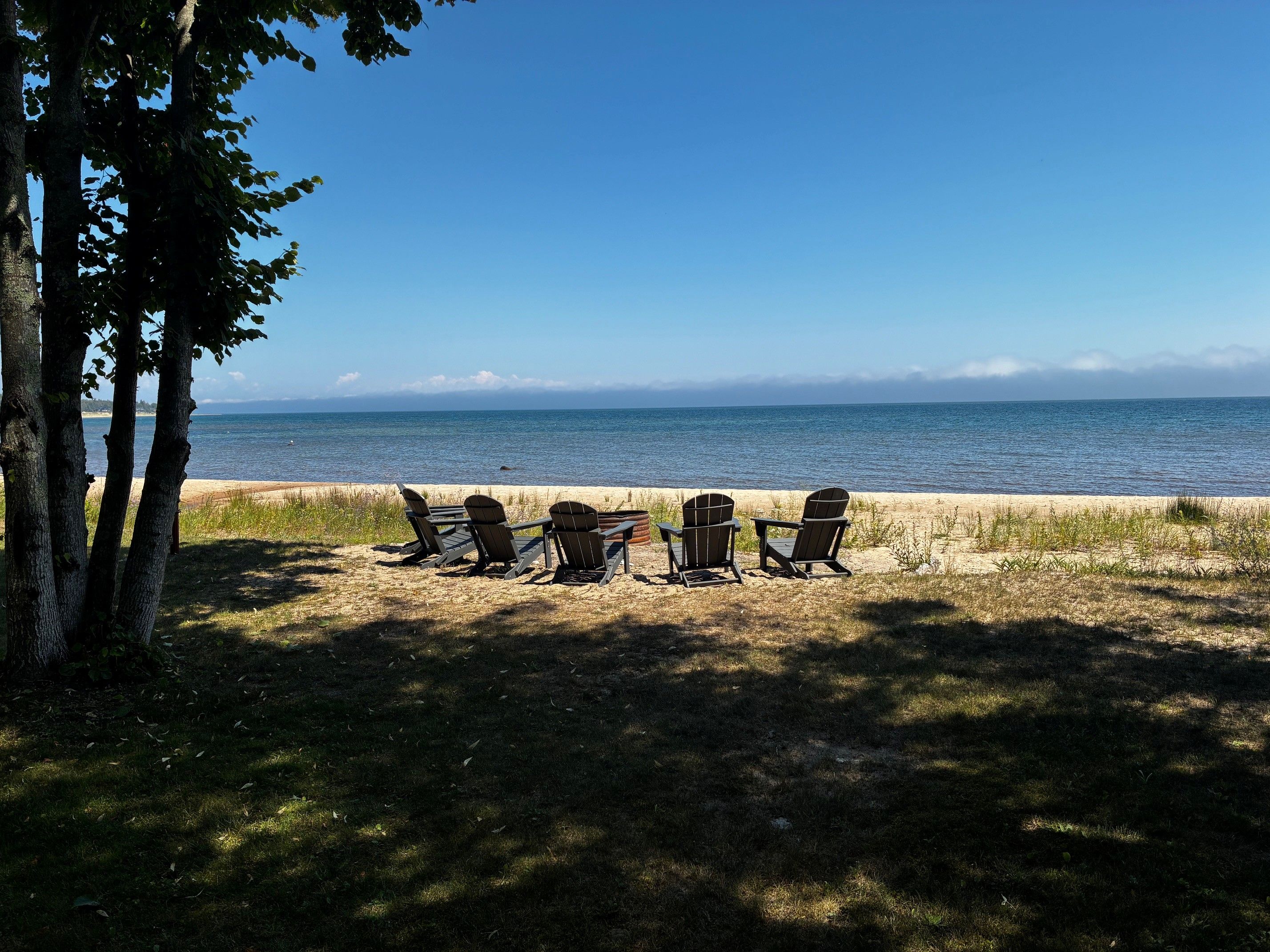 A beachside seating area with Adirondack chairs facing the ocean.