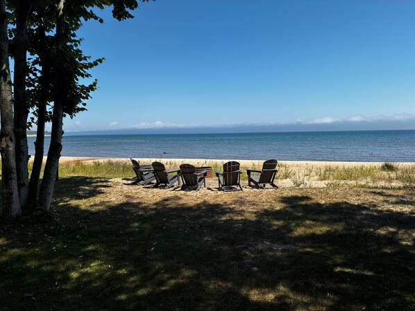 A beachside seating area with Adirondack chairs facing the ocean.
