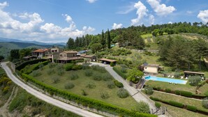 A hillside property with multiple houses, a swimming pool, and a winding road. - Villa Olivi Pool by Geco Vacation Rentals (Pergine Valdarno)