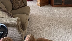A living room with a wooden staircase, a red sofa, a beige sofa, a wooden entertainment center, and a ceiling fan. - House close to Pine Lake and bike trails. (Eldora)