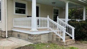 A two-story house with a covered porch and a staircase leading to the entrance. - House close to Pine Lake and bike trails. (Eldora)