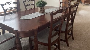 A dining room with a wooden table, six chairs, a ceiling fan, and a plant centerpiece. - House close to Pine Lake and bike trails. (Eldora)