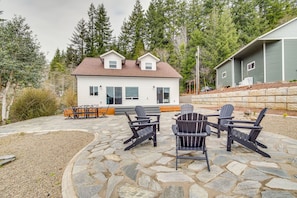 Enjoy outdoor dining or relaxation on the stone patio, surrounded by a well-maintained garden.