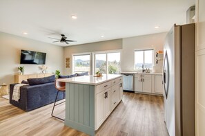 Relax in a cozy living area with a comfortable sofa and flat-screen TV, or cook in the well-equipped kitchen with a large island and dishwasher.