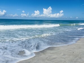 Una playa con olas y cielo despejado.