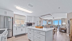 A modern kitchen with white cabinets, stainless steel appliances, and a large island with drawers. - Beach Club B1701 | Beachfront | Corner | Resort | Arcade | Pools | Hot Tubs (Gulf Shores)