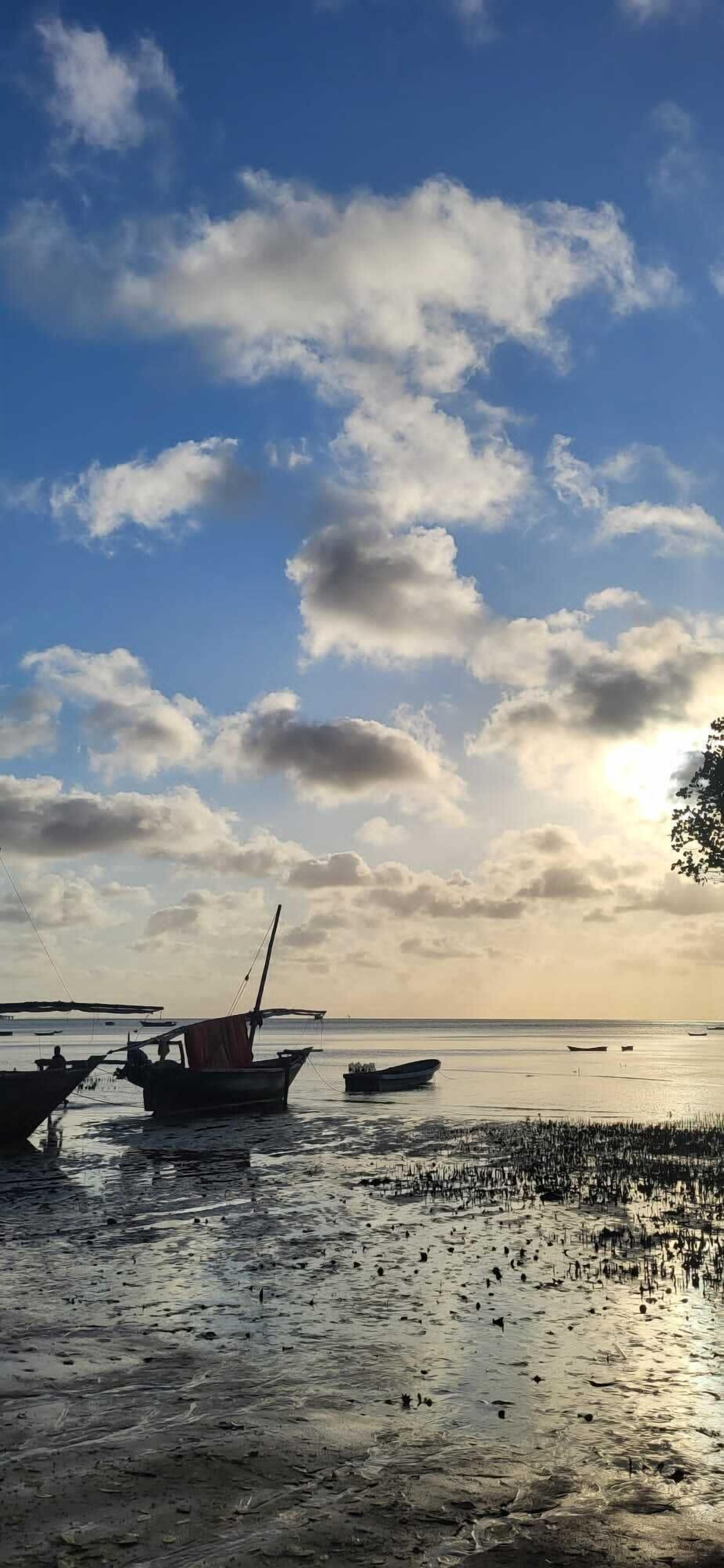 A beach with boats and calm water.