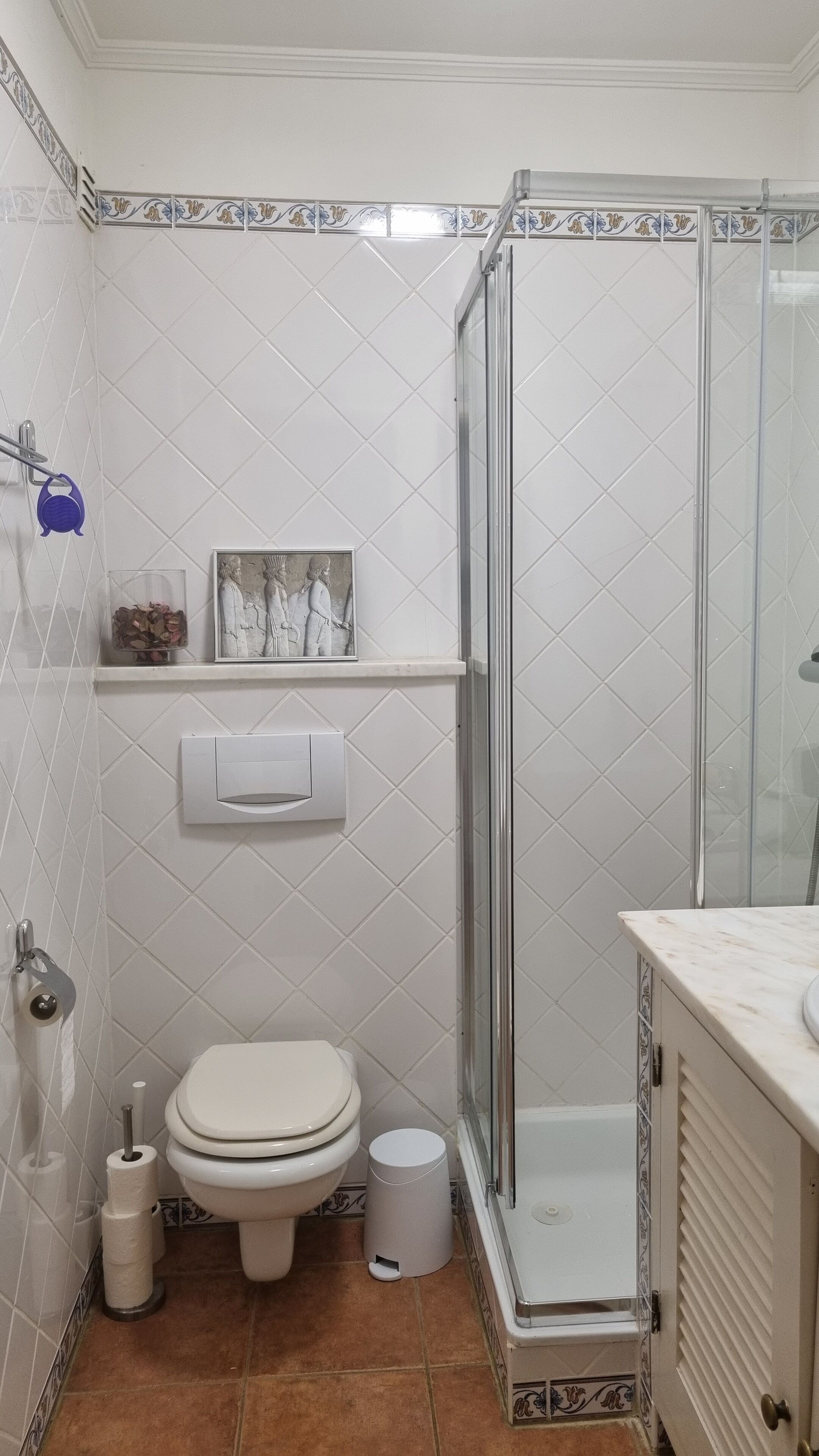 Une salle de bain avec des toilettes, une douche et un lavabo.