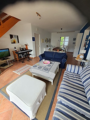 Amplia sala de estar con un sofá, una mesa de centro y un televisor.