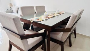 A dining table with six chairs, a floral placemat, and a white teapot. - Napoles (Mazatlán)