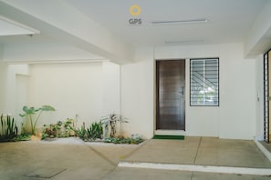 A clean, modern entrance with a metal gate, a concrete floor, and a small green mat. - Napoles (Mazatlán)