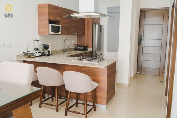 Departamento urbano | Cocina privada | Refrigerador con congelador, microondas, parrilla de estufa y licuadora 