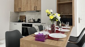 Een moderne keuken met houten kastjes, een marmeren aanrecht en een eethoek gedekt voor een maaltijd.