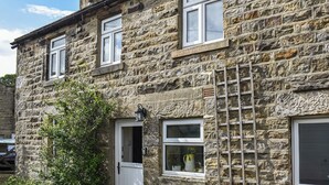 A stone building with multiple windows, a door, and a ladder. - 2 bedroom accommodation in Middlesmoor, near Pateley Bridge (Middlesmoor, near Pateley Bridge)