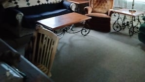 A cozy living room with a sofa, armchair, and coffee table.