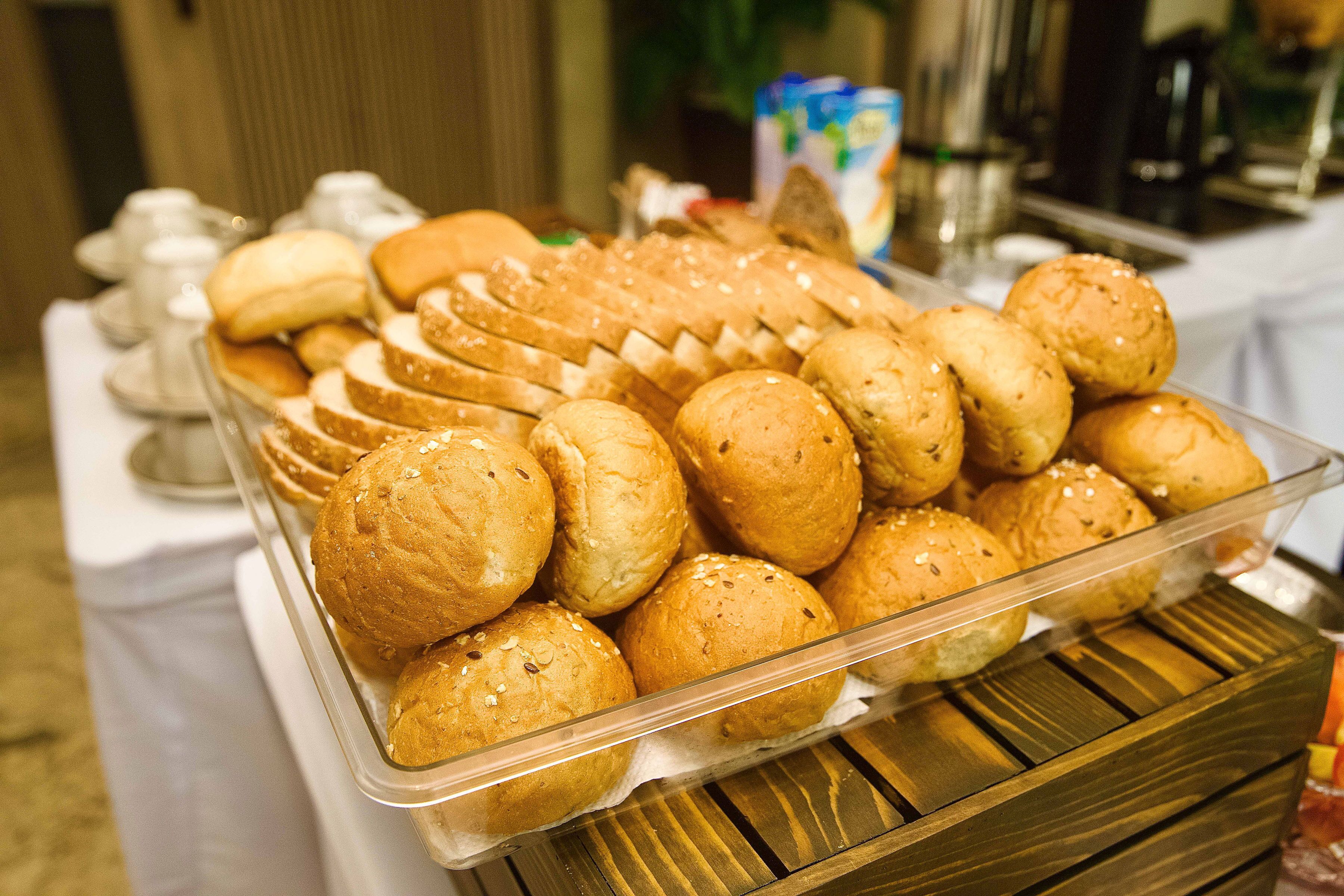 Een schaal met verschillende broodjes en gebak op een tafel.