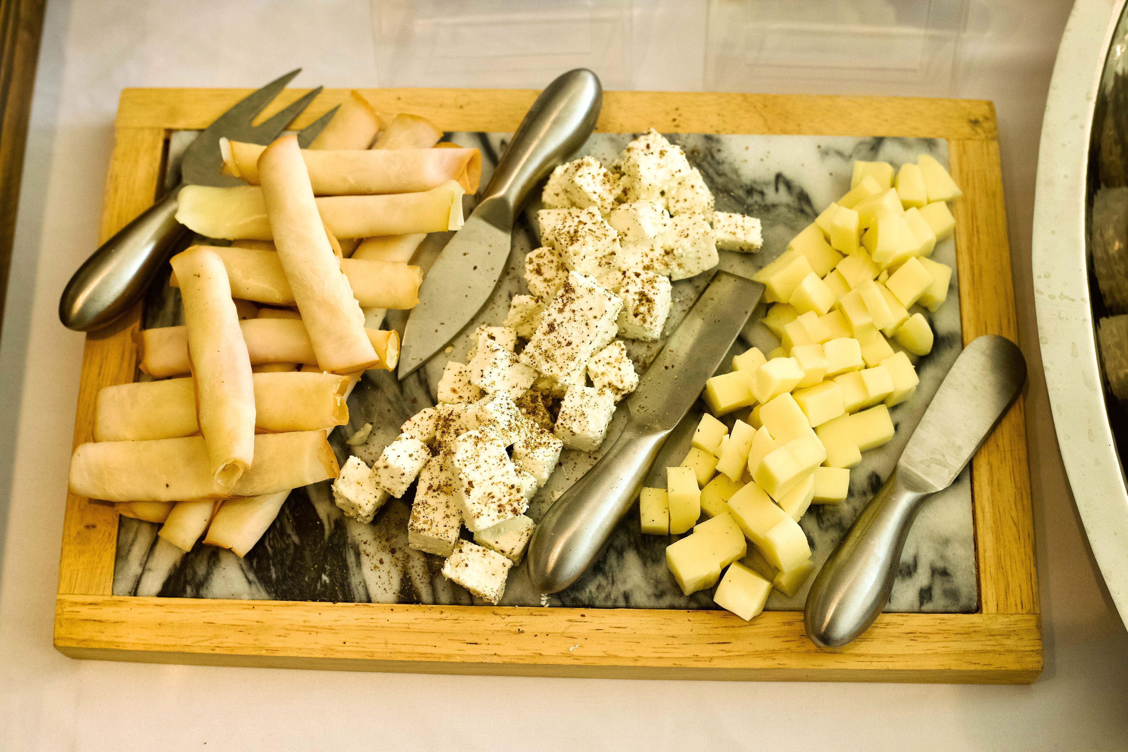 Une planche en bois garnie de différents fromages et de crackers.