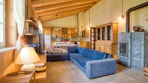 A cozy living room with a blue sofa, a wooden ceiling, and a stone fireplace. - Lovely home in Farnese (Farnese)