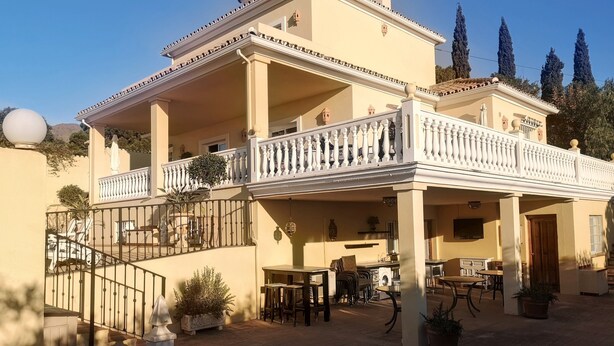 A two-story building with a balcony, outdoor seating area, and potted plants. - Villa Roca, Lejlighed til 2 Personer, 3km til Estepona (AN)