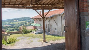 A rustic stone building with a wooden roof structure and a brick wall. - Majoa - Villecheneve (VILLECHENEVE)