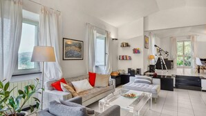 A modern living room with a sofa, armchairs, a coffee table, and a telescope. - 3 bedroom gorgeous home in Rapallo (Rapallo)