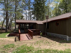 Eine Holzhütte mit einer Terrasse, umgeben von Bäumen.