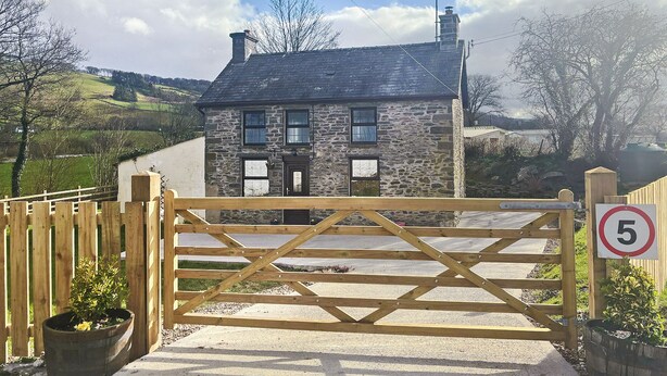 A stone cottage with a wooden gate, surrounded by a rural landscape. - 2 bedroom accommodation in Tregaron, near Lampeter (Tregaron, near Lampeter)