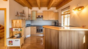 A kitchen with wooden cabinets, a central island, and a window with blinds.