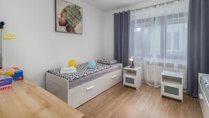 A modern bedroom with a bed, bedside tables, a desk, and a window with curtains. - Amazing home in Lic with WiFi (Lic)