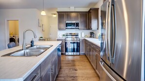 A modern kitchen with stainless steel appliances, a wooden floor, and pendant lighting. - GLOBALSTAY. New House 7 Bd in Port Elgin. Close to the Beach (Port Elgin/Canada)