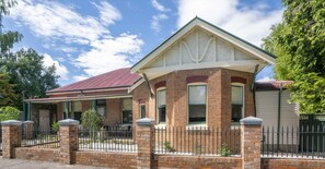 Stunning two-story home with a gabled roof and covered porch, featuring a symmetrical facade and central entrance.