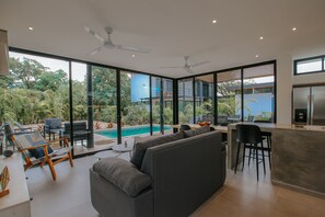 Un espacio habitable moderno con piscina, asientos exteriores y área de cocina.
