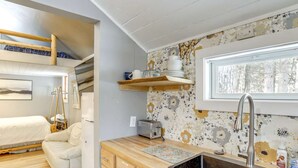 Una cocina compacta con un lavamanos integrado, una ventana y una encimera de madera.