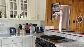 A kitchen with white cabinets, a black stove, and wooden accents.