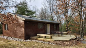 Eine Blockhütte mit einer Veranda und einem Picknicktisch.
