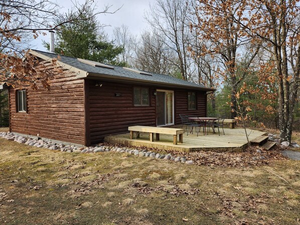Eine Blockhütte mit einer Veranda und einem Picknicktisch.