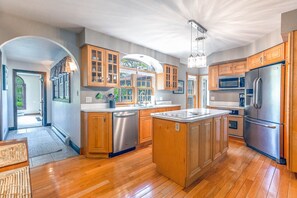A modern kitchen with wooden cabinets, stainless steel appliances, and a central island.