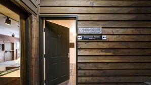 Pared exterior de madera con una puerta etiquetada como '102' y un letrero que indica 'Slopeside Haven Angel Fire'.