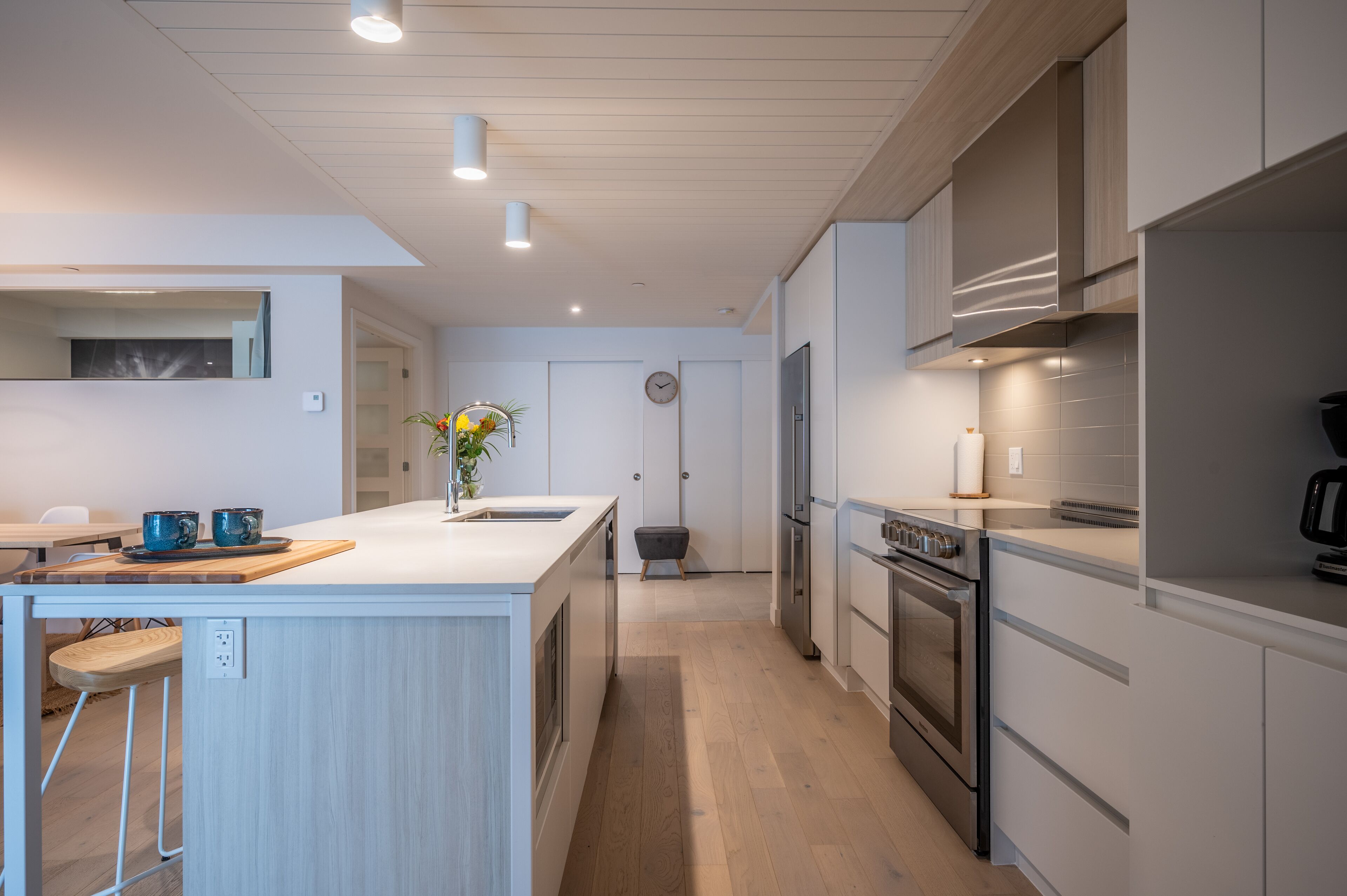 A modern kitchen with a central island, stainless steel appliances, and a minimalist design.
