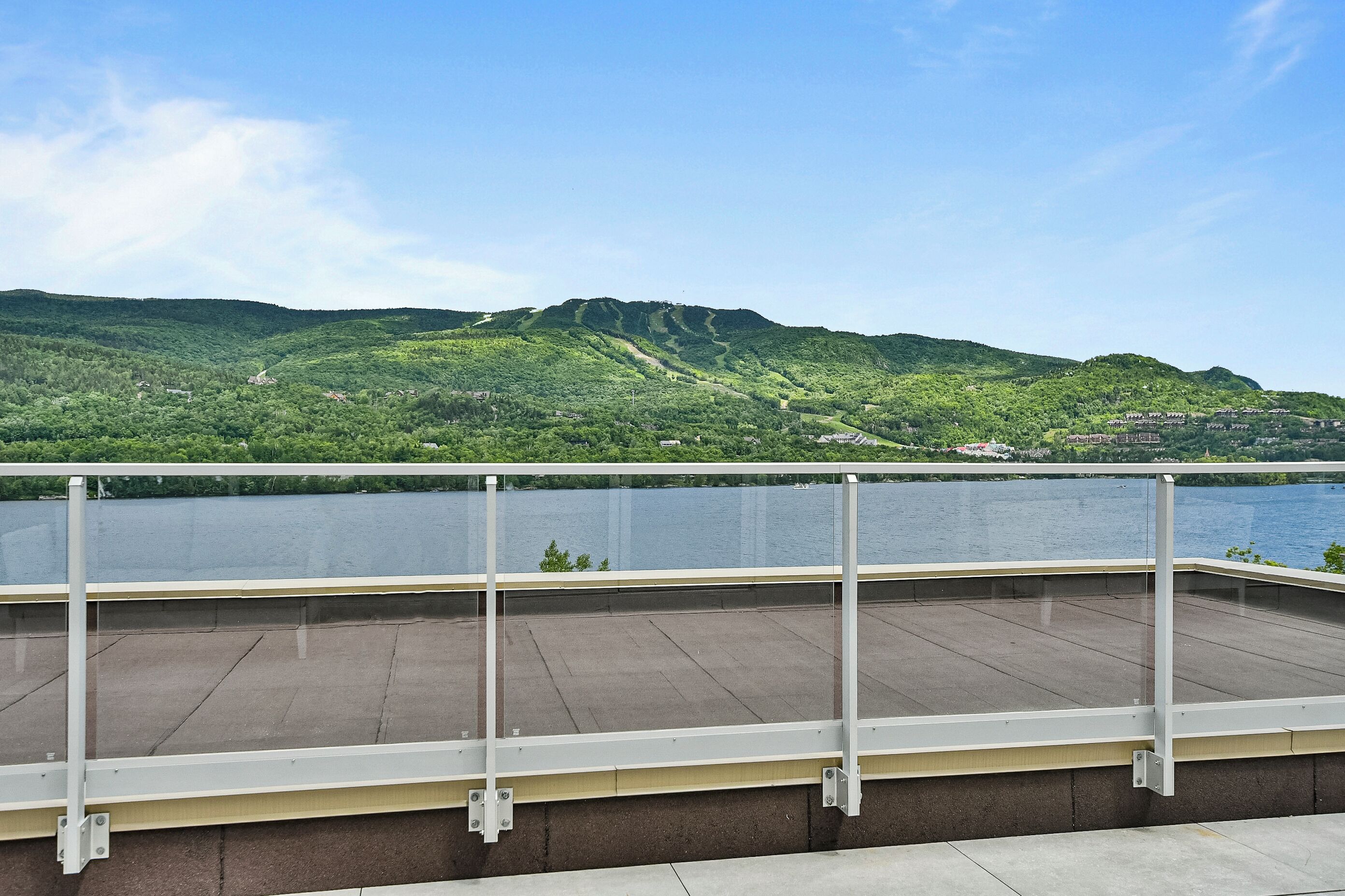 Une terrasse avec vue sur un lac et des collines.