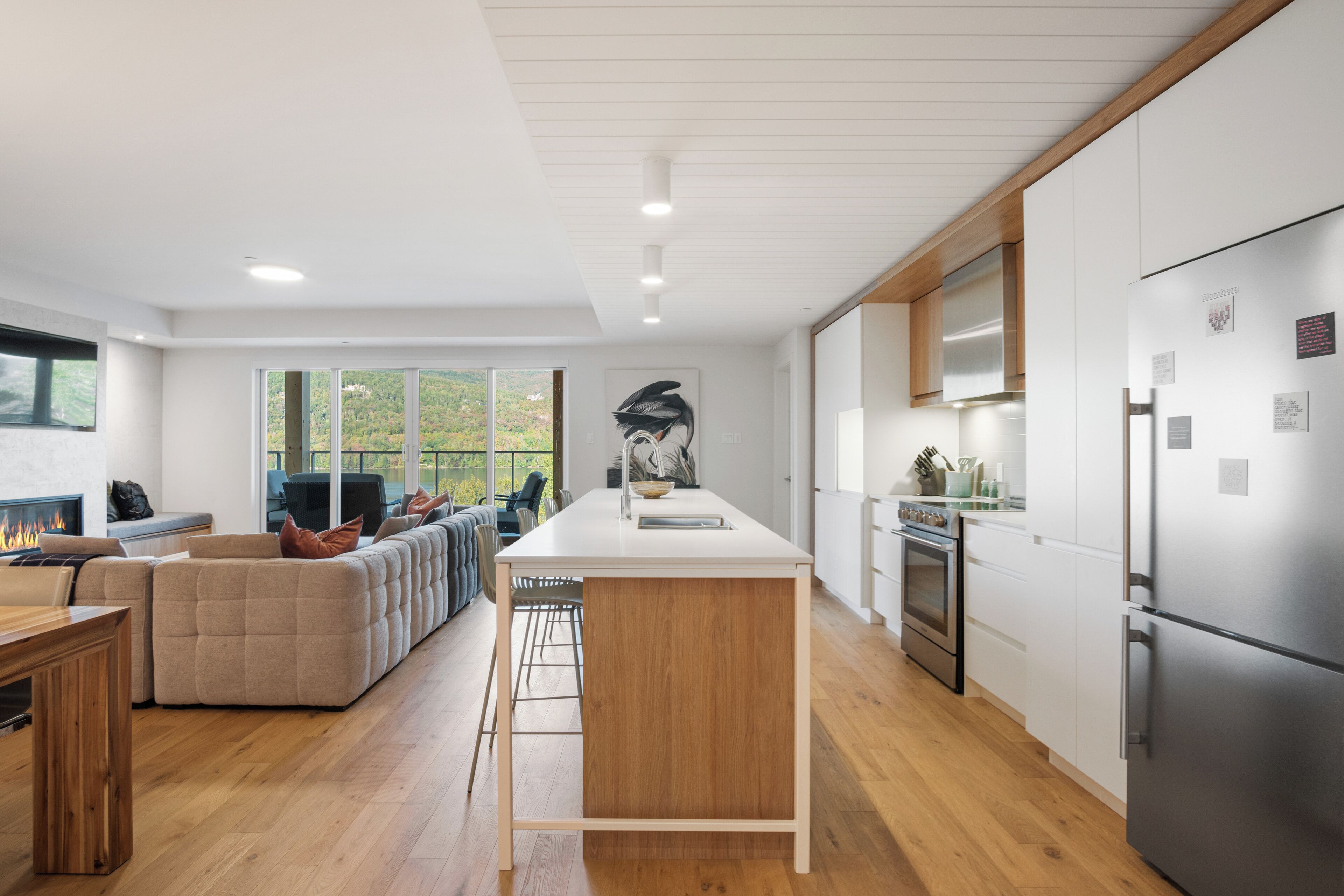Una cucina moderna con isola centrale, pavimento in legno e un frigorifero grande.