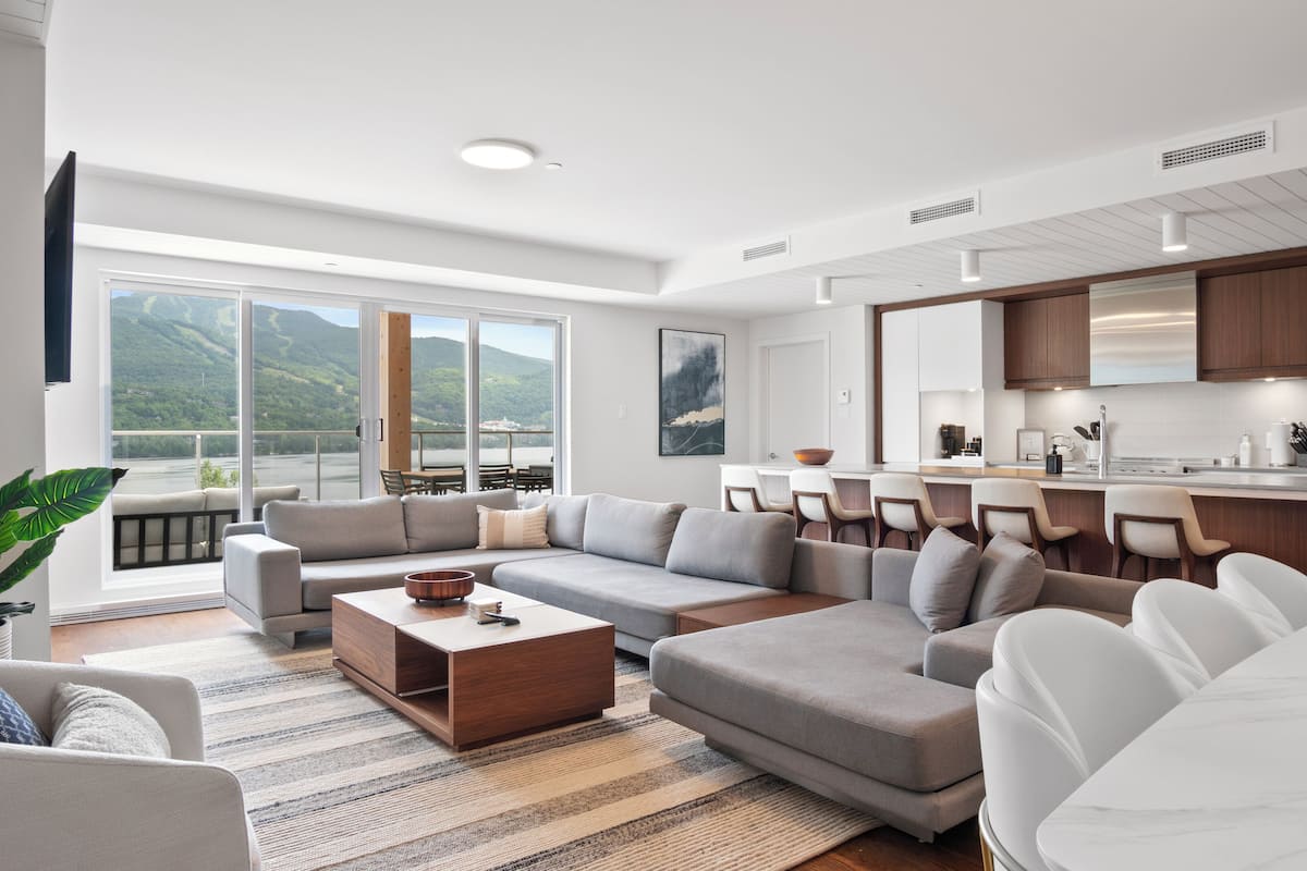 Een moderne woonkamer met een royale zithoek, een salontafel en een eethoek met stoelen.
