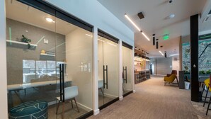 A modern office space with glass partitions, a long corridor, and a seating area with chairs and a sofa. - Alpine Escape Studio by Park City Vacations (Park City)
