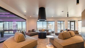 A modern lounge area with sofas, a coffee table, and a large pillar. - Alpine Escape Studio by Park City Vacations (Park City)
